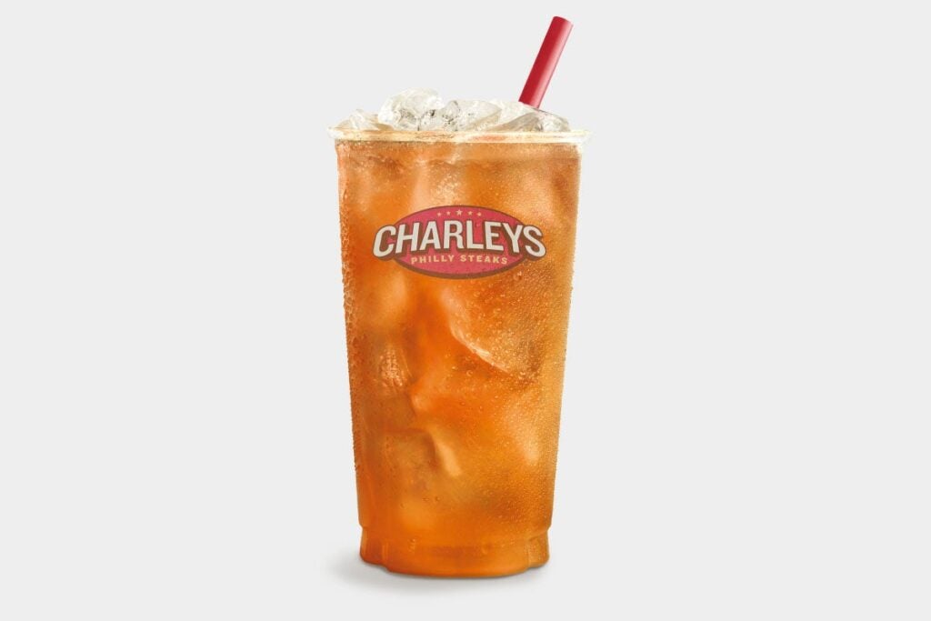 Black iced tea in a clear cup with the Charleys Cheesesteaks logo and a red straw.
