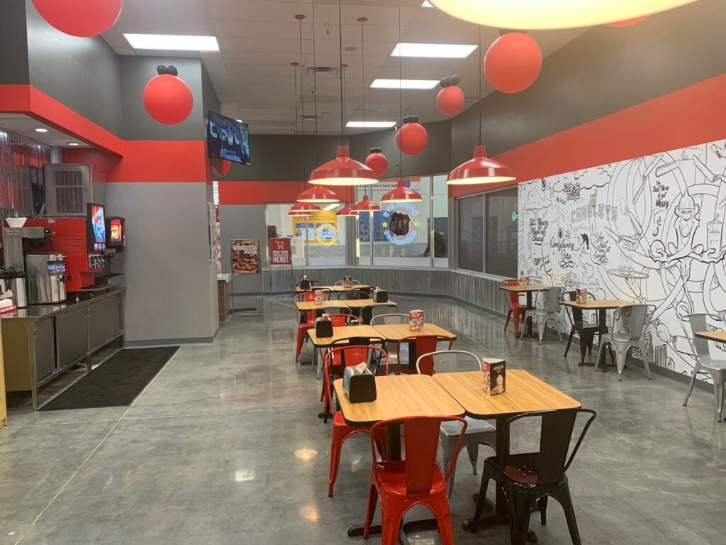 Tables and chairs in the dining area at Charleys Cheesesteaks and Wings at Commercial Way Walmart 