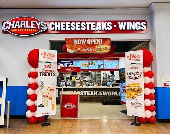 The entrance of Charleys Cheesesteaks and Wings at Highway 6, surrounded by balloons and signs.  