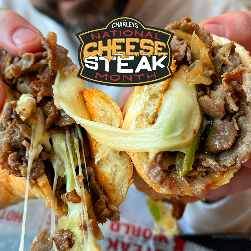A cheesesteak being pulled apart with an emblem staying 